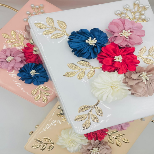 Decorative clutch with flowers and gold leaves on a light background
