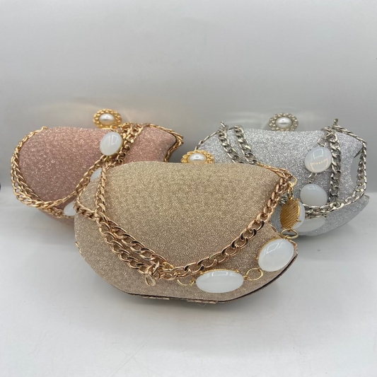 Three decorative bags with chains and pearls on a light gray background