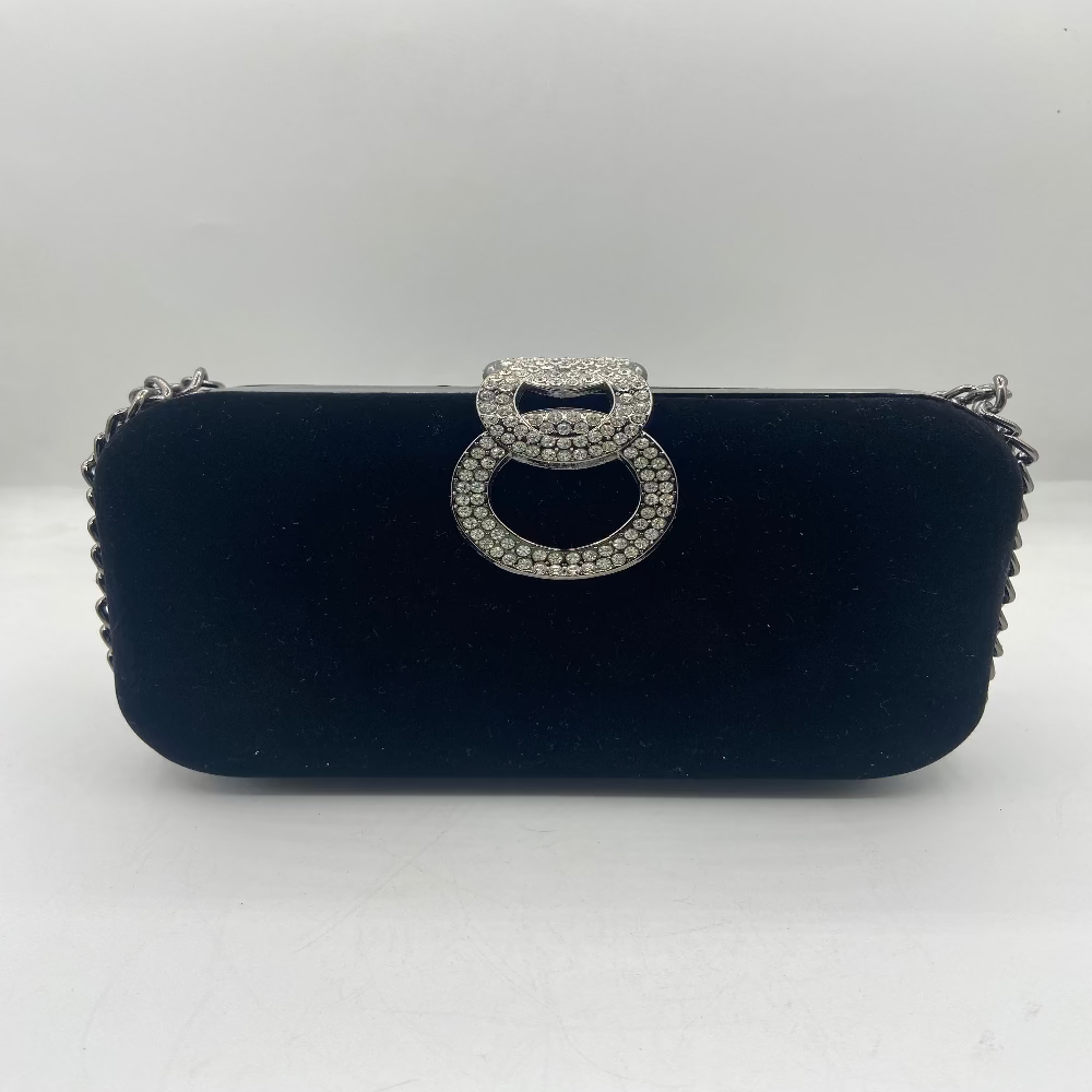 Black clutch bag with a decorative silver ring on a white background