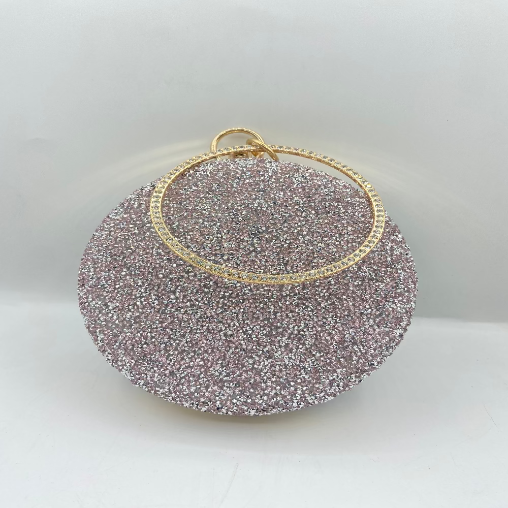 Round glittery clutch bag with gold rim on a white background